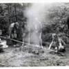 Roasting a chicken on a spit over the coals. c1936 Margy Hall photos